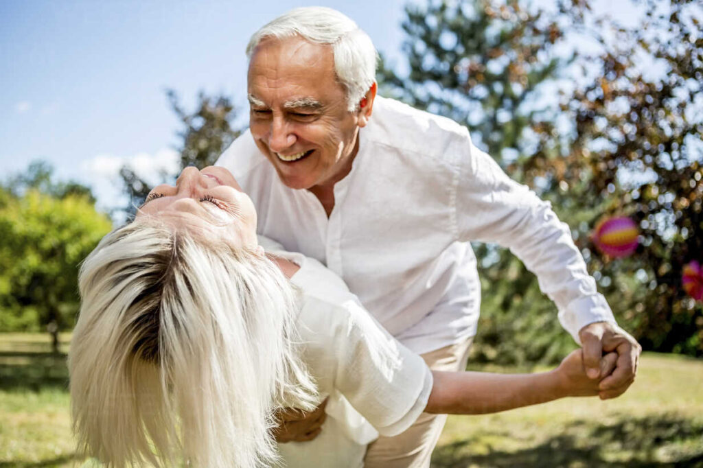 Happy elderly couple dancing outdoors